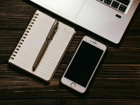 A notebook and a pen beside a phone