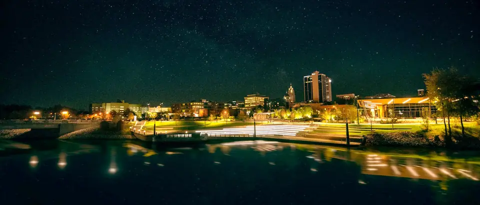 Fort Wayne's skyline lit up at night across the river