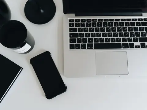 A laptop and a phone on a white desk