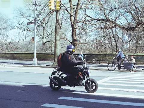 A rider on a motorcycle crossing a city intersection