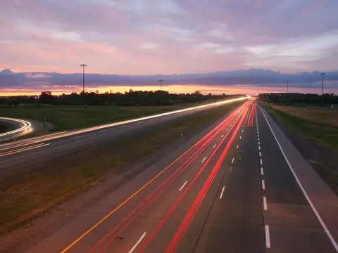 A highway at dusk with light trails from traffic